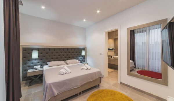 King size bed in a bedroom with en suite bathroom of a Croatia luxury vacation villa with private pool and parking