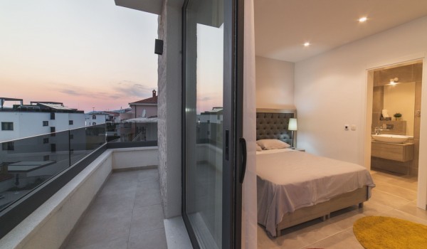 King size bed in a bedroom with en suite bathroom of a Croatia luxury vacation villa with private pool and parking