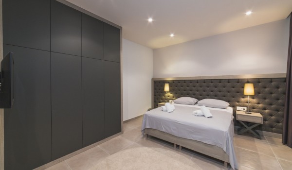 King size bed in a bedroom with en suite bathroom of a Croatia luxury vacation villa with private pool and parking