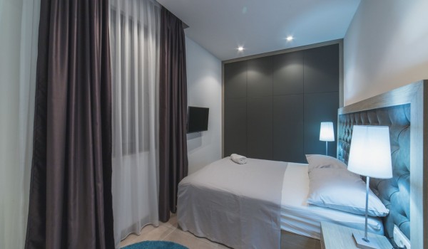 King size bed in a bedroom with en suite bathroom of a Croatia luxury vacation villa with private pool and parking