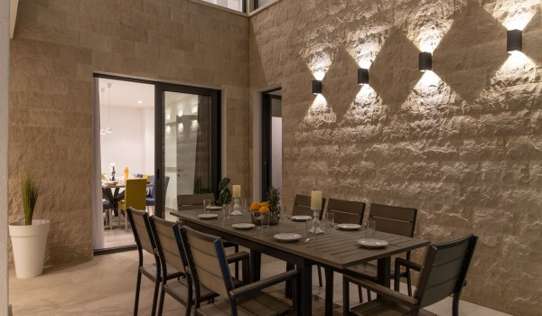 Night view of a  dining table on the terrace in a Croatia luxury sea view villa with gym and sauna in Trogir