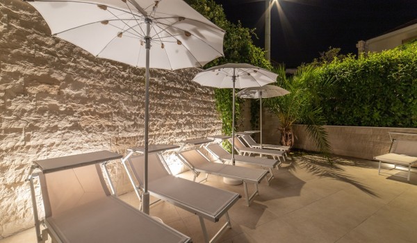 Night view of deck chairs on the terrace in a Croatia luxury sea view villa with gym and sauna in Trogir