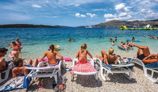 Pebbly and sandy beach in front of a Croatia luxury family villa for vacation and rent in Trogir