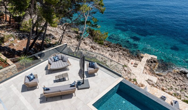 Seafront terrace with a lounge zone and a sea-view by the infinity pool in front of the luxury 6-bedroom villa for family vacations on Korcula