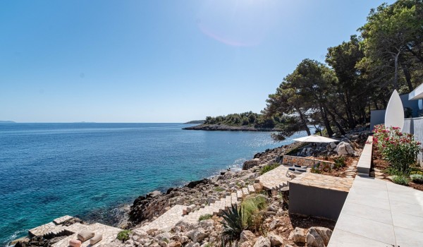 Several sunbathing plateaus surrounded by stone walls with private access to the beach in front of the seafront exclusive villa for 12 Miracul Korcula