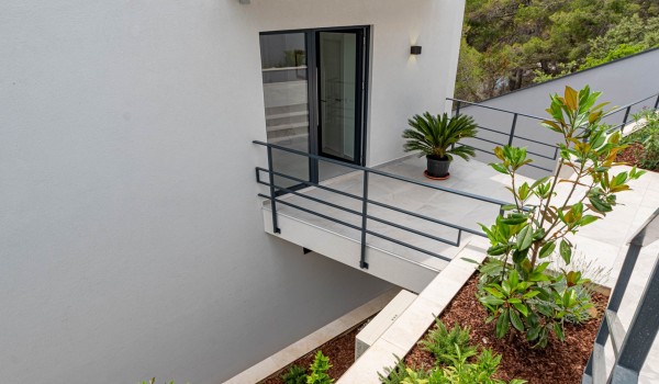 Exterior with carefully landscaped greenery and a main entrance to the exclusive pool villa Korcula Miracul for family vacations by the sea