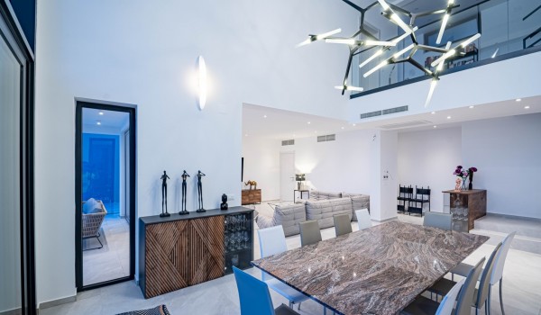 Elegant dining area with a table, chairs and modern lighting on the ground floor of the villa Miracul for family vacations on Korcula