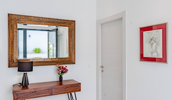 A painting, wooden table and a mirror on the first floor of the Dalmation luxury beachfront villa Miracul with a private pool and gym