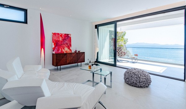 Lounge area with white modern armchairs and glass gliders to the balcony on the first floor of the exclusive villa for rent and vacation Miracul with a private pool on Korcula