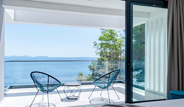 A view from the bedroom on a balcony with a panoramic sea view, coffee table, and two chairs on the first floor of the luxury villa Magnificent Korcula in Prizba