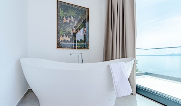 A bathtub next to the glass wall by the private balcony of a bedroom on the 1st floor of the villa for rent and vacations Miracul Korcula