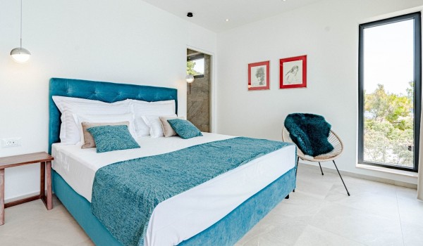 Interior of bedroom with en suite bathroom and king-size bed in a  luxury villa by the sea for rent on the island of Korcula