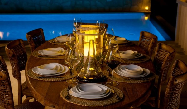 A richly decorated wooden table with chairs located next to the spacious pool of the Croatia  luxury villa Brač