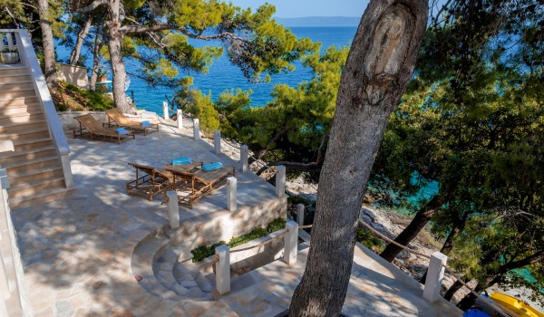 Stone-paved sun terrace directly by the sea of Brač holiday villa in Sumartin