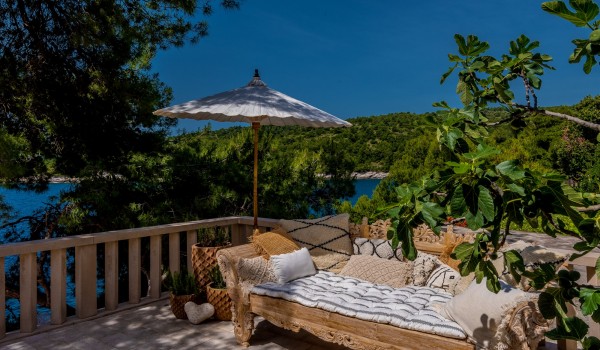 Luxurious sofa on the outdoor terrace surrounded by a dense pine forest on the island of Brač, in the town of Sumartin
