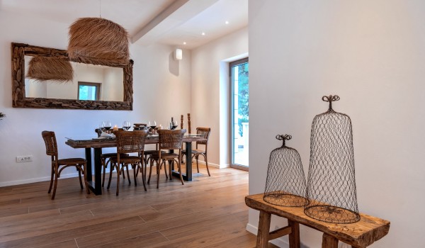 Wooden dining table with chairs and accompanying details in a luxury holiday villa on the island of Brač