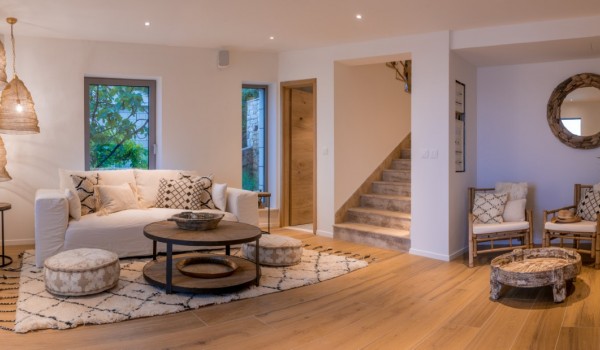 A view of the luxuriously decorated living room with a toilet and an outdoor terrace with a dining table and chairs in the luxury villa Bliss on the island of Brač