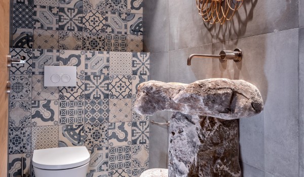 A luxurious stone sink with a modern mirror in one of the en suite bathrooms of a luxury vacation villa on the island of Brač
