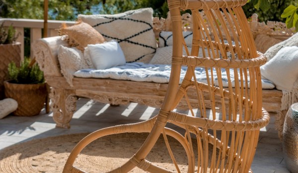 A hanging garden swing with a sofa on the outdoor airy terrace of a luxury holiday villa in Sumartin