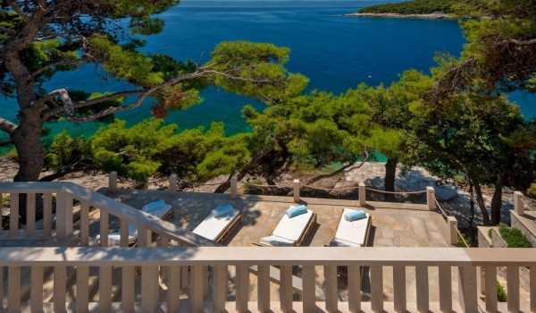 Spectacular view from the outdoor terrace on deckchairs surrounded by a dense pine forest and the blue of the Adriatic Sea