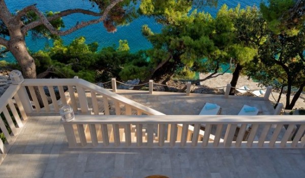 Luxuriously decorated dining table with chairs overlooking the crystal blue sea and the island of Hvar