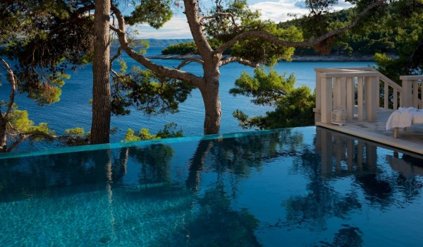 A magical view from the spacious pool of pine trees and the calm sea from the villa property for rent and vacation Brač by the sea