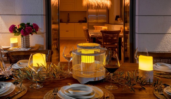 Richly decorated dining table with chairs on the outdoor airy terrace of this villa for rent on the island of Brač