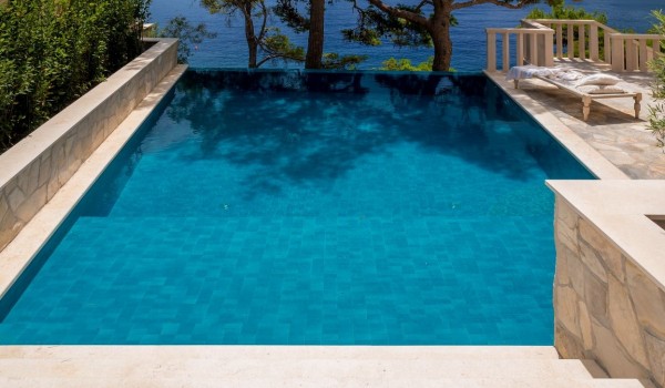 A spacious swimming pool with steps on the property of a Croatia  luxury villa for a complete Brač family vacation