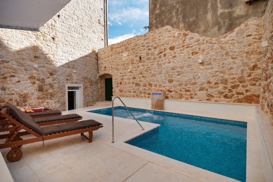 Ležaljke za sunčanje i odmor pored privatnog bazena na vanjskoj terasi hrvatske luksuzne vile za najam i odmor u Bolu na otoku Braču