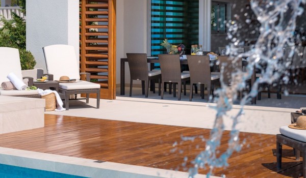 View of a modern air-conditioned open space living room overlooking a large swimming pool in a private villa for rent and vacation in Brela