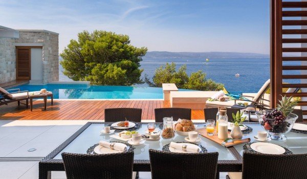 A table set for family gatherings with friends of the luxury villa for rent Brela Pride with a view of the pool, sea and islands in Brela next to the beach with private parking