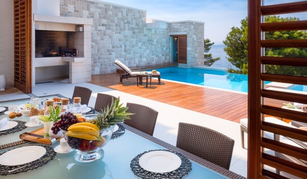 Outdoor living room with dining table and barbecue in the most beautiful luxury villa with pool for rent in Brela, by the sea for ten people