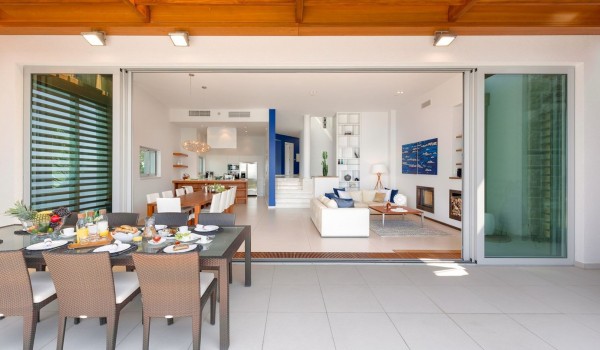View from the terrace of the living room with dining room and modern kitchen of a private vacation villa with pool in Brela