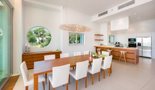 A spacious dining room with a table for 10 people and a kitchen with an island in the luxury holiday villa Brela Pride in Brela