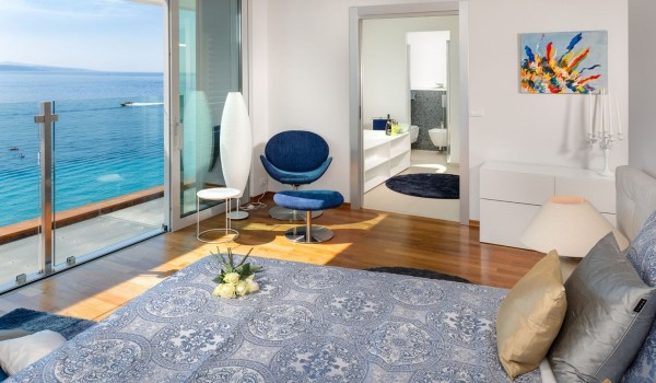 Comfortable king size bed in a bright bedroom with en suite bathroom for rent by the sea, where pets are allowed