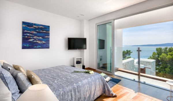 Elegantly decorated interior of an air-conditioned bedroom with a king size bed, Smart TV of the luxury villa for rent and vacation Brela Pride by the beach