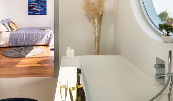View of a modern bedroom with an en suite bathroom in a private villa with a heated pool and on-demand chef service in a private villa in Brela next to the beach and the sea