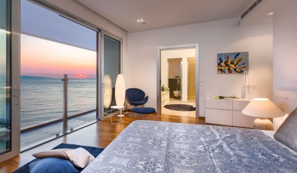 Comfortable king-size bed in a spacious air-conditioned bedroom with en suite bathroom of a luxurious private villa for rent and vacation with family and friends by the sea in Brela