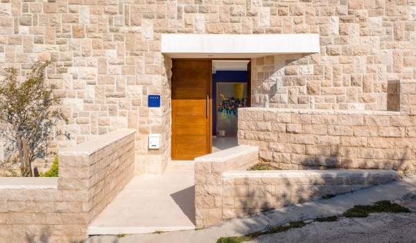 The main entrance to a luxurious private villa for rent and vacation with a heated infinity pool and concierge service by the sea and the beach in Brela for ten people