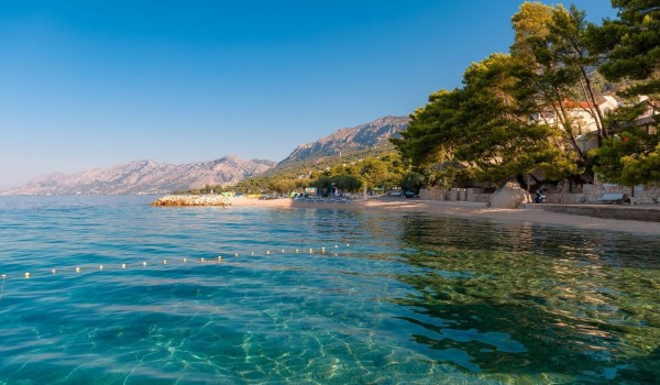 Crystal turquoise sea next to a pebble beach in front of a family pet-friendly villa for rent and vacation in Brela