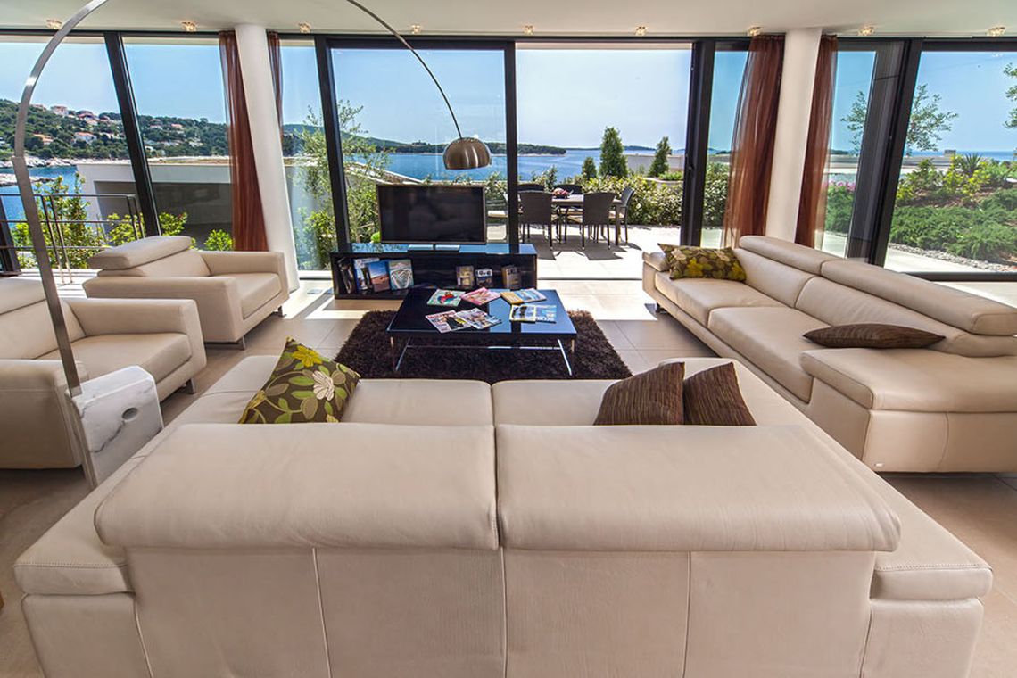 A spacious, naturally lit living room with a view of the crystal blue sea in Primošten