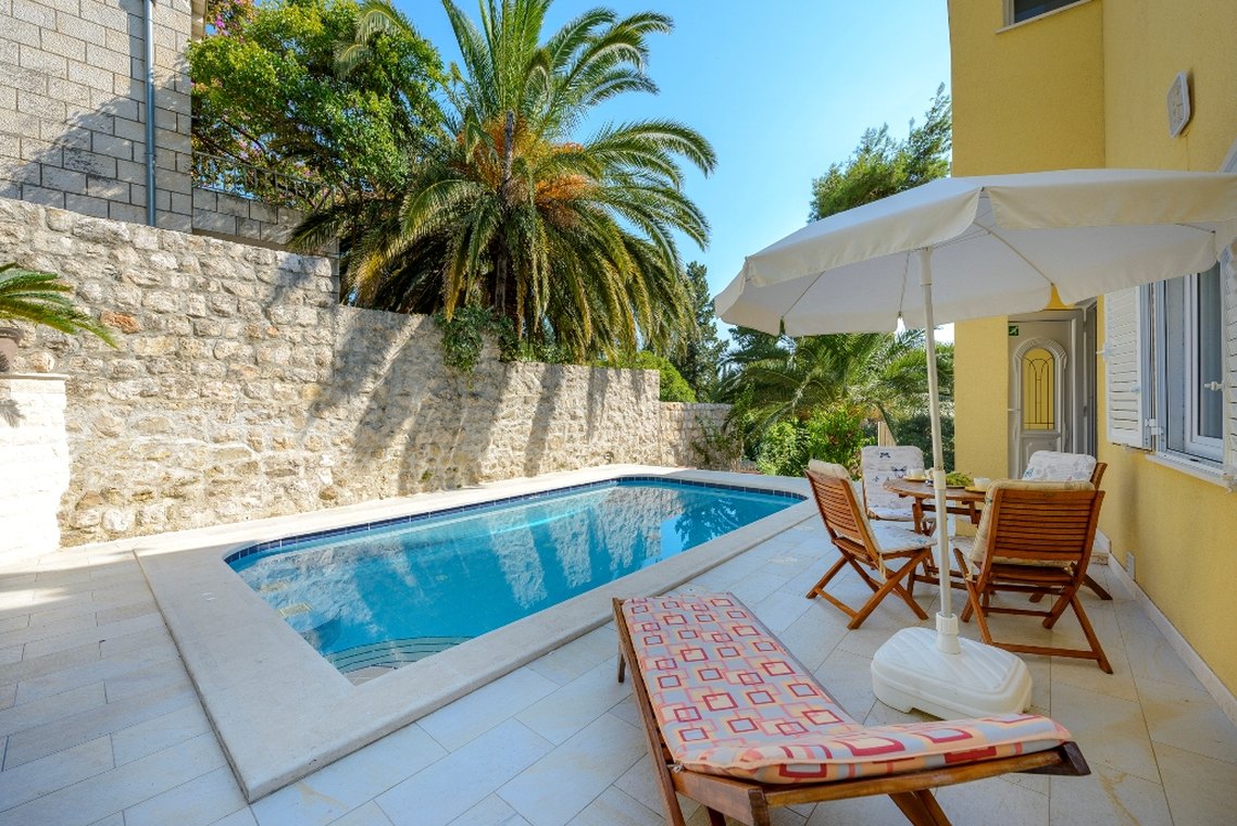 Pogled na vanjsku terasu hrvatske luksuzne vile za odmor Dubrovnik Garden sa privatnim bazenom i ležaljkama za sunčanje u mjestu Mlini u blizini Dubrovnika