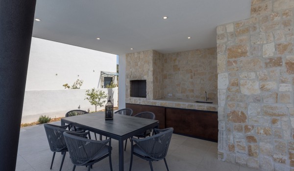 Outdoor dining table with fireplace of Croatia luxury pool villa for vacation and rent