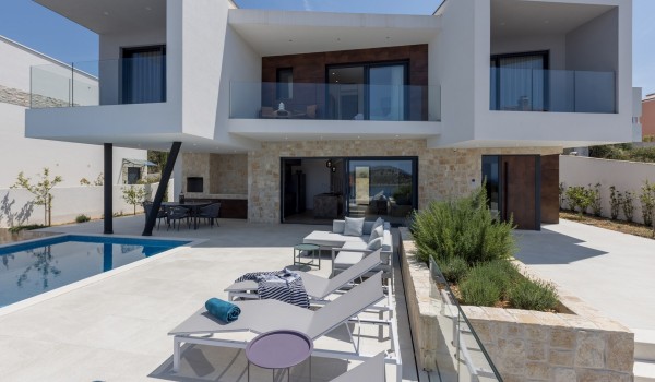 Outdoor private terrace of Croatia luxury holiday villa with infinity pool and deckchairs for rent