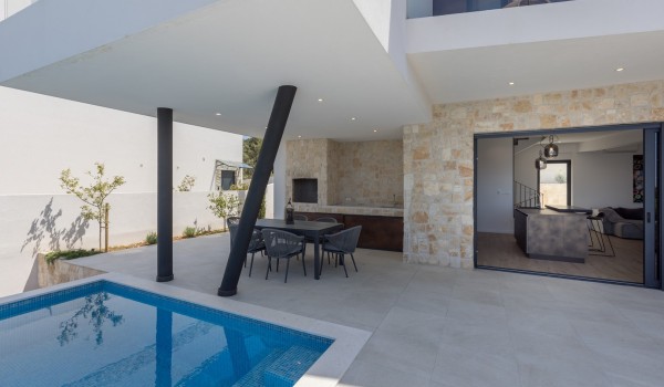 Outdoor private terrace of Croatia luxury holiday villa with infinity pool and deckchairs for rent