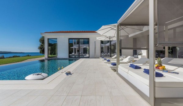 Sun loungers with sea view by the private pool of a Croatia luxury seafront villa Eden Land with sauna and jacuzzi in Istria