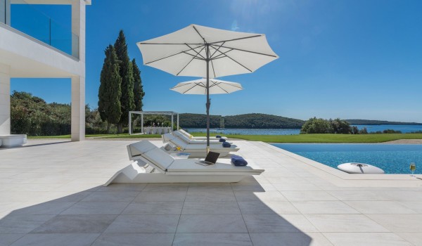 Sun loungers with sea view by the private pool of a Croatia luxury seafront villa Eden Land with sauna and jacuzzi in Istria