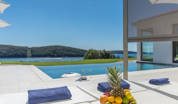 Sun loungers with sea view by the private pool of a Croatia luxury seafront villa Eden Land with sauna and jacuzzi in Istria