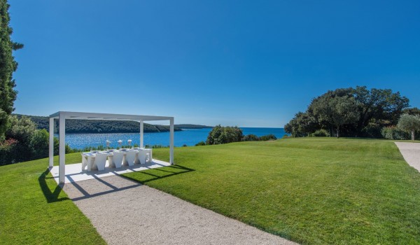 View of the covered outdoor dining table in the garden of a Croatia luxury pet-friendly villa with concierge service and parking in Istria