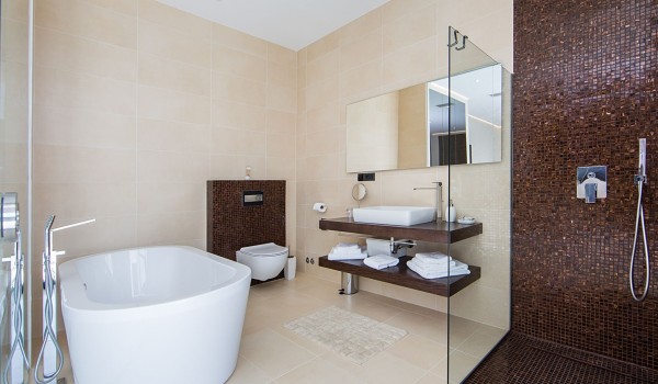 En suite bathroom with bathtub and walk-in shower in a Croatia luxury seafront villa with sauna and jacuzzi in Istria